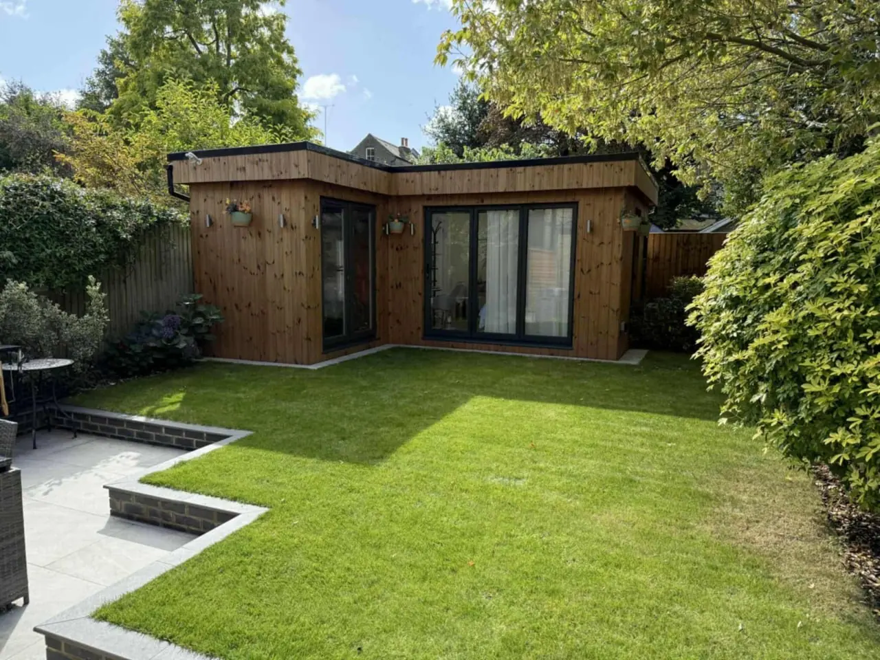 Contemporary cedar garden room with full-height glazing and a broad deck